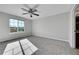 Spacious bedroom featuring a ceiling fan, carpet floors, and a large window at 7511 S Sicily Way, Aurora, CO 80016