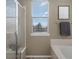 Bright bathroom with tile flooring, neutral walls, window and glass enclosed shower at 9599 Cedarhurst Ln # A, Highlands Ranch, CO 80129