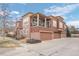 Multi-level townhouse boasts a brick and stucco exterior, three garage spaces, and a private covered balcony at 9599 Cedarhurst Ln # A, Highlands Ranch, CO 80129