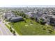 Aerial view of a residential community with a central green space featuring picnic tables and mature trees at 18875 W 93Rd Ave, Arvada, CO 80007
