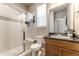 Well-lit bathroom featuring a glass-enclosed shower, wood vanity, and modern fixtures at 18875 W 93Rd Ave, Arvada, CO 80007