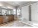 Well-lit bathroom featuring a modern glass shower and a spacious vanity with dual sinks and wood cabinets at 18875 W 93Rd Ave, Arvada, CO 80007