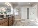 Bright bathroom featuring a double vanity with dark countertops and a glass-enclosed shower with decorative tile at 18875 W 93Rd Ave, Arvada, CO 80007