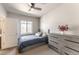 Comfortable bedroom featuring a ceiling fan, a window for natural light, and a dresser for storage at 18875 W 93Rd Ave, Arvada, CO 80007