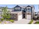 Beautiful two-story home with stone accents, blue siding, and a well-manicured front yard at 18875 W 93Rd Ave, Arvada, CO 80007