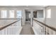 Upstairs hallway featuring neutral walls and carpet with views to other rooms and neighborhood through several windows at 18875 W 93Rd Ave, Arvada, CO 80007