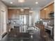 Spacious kitchen featuring stainless steel appliances, dark countertops, a large island, and ample cabinet space at 18875 W 93Rd Ave, Arvada, CO 80007
