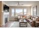 Cozy living room with a fireplace, leather sofa, and ample natural light at 18875 W 93Rd Ave, Arvada, CO 80007