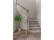 A well-lit staircase with hardwood floors, carpeted steps, and a white railing ascends to the upper level at 18875 W 93Rd Ave, Arvada, CO 80007
