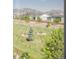A serene view of a landscaped green space with picnic benches and mature trees in the neighborhood at 18875 W 93Rd Ave, Arvada, CO 80007