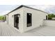 Exterior view of house with white siding, black trim, deck and outdoor lighting at 1541 Glencoe St, Denver, CO 80220
