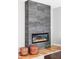 Modern fireplace with gray tiling, hardwood floors, and stylish leather poufs at 1541 Glencoe St, Denver, CO 80220