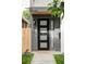 Modern black front door with glass panes, set in a gray facade with house number at 1541 Glencoe St, Denver, CO 80220