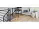 Bright hallway with hardwood floors, metal railing, and seating area at 1541 Glencoe St, Denver, CO 80220