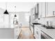 Bright white kitchen with modern appliances, sleek cabinetry, and hardwood floors at 1541 Glencoe St, Denver, CO 80220