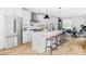 Modern white kitchen with stainless steel appliances, large island, and hardwood floors at 1541 Glencoe St, Denver, CO 80220