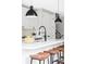 Bright kitchen island with white countertops, modern faucet, and barstool seating at 1541 Glencoe St, Denver, CO 80220