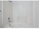 All-white bathroom with tub and shower and classic tile at 3855 Canyon Ranch Rd # 104, Highlands Ranch, CO 80126