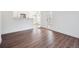 Open living space with hardwood floors, white walls, and a view into the kitchen at 3855 Canyon Ranch Rd # 104, Highlands Ranch, CO 80126