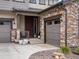 Close-up of the front entrance with a stone garage and cozy porch at 3187 S Quaker St, Morrison, CO 80465