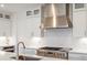 Modern kitchen featuring stainless steel range hood and subway tile backsplash at 3187 S Quaker St, Morrison, CO 80465