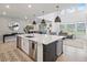 Open-concept living space with a large kitchen island with seating and stainless steel appliances at 3187 S Quaker St, Morrison, CO 80465
