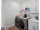 This laundry room features modern washer and dryer units with a built-in sink and cabinet storage at 3187 S Quaker St, Morrison, CO 80465