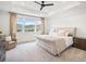 Bright primary bedroom features a tray ceiling, mountain views and a comfortable seating area at 3187 S Quaker St, Morrison, CO 80465