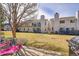 Townhome backyard showcasing a well-maintained lawn, patio, and exterior views of the building at 1303 S Danube Way # 104, Aurora, CO 80017