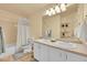 Bathroom with double sink vanity, bathtub and shower combo, and a large mirror with decorative lighting at 1303 S Danube Way # 104, Aurora, CO 80017