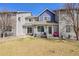 Back of townhomes with a lawn, patios, and various amenities, accented by trees and blue trim at 1303 S Danube Way # 104, Aurora, CO 80017