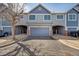 Exterior front view of townhome with grey and blue tones and two-car garage at 1303 S Danube Way # 104, Aurora, CO 80017