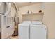 Functional laundry room with washer, dryer, shelf storage, and utilities including a furnace and water heater at 1303 S Danube Way # 104, Aurora, CO 80017