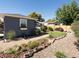 Landscaped backyard with a pergola lounge area, garden shed, gravel path, and beautiful plants at 2482 Otis Ct, Edgewater, CO 80214