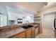 Kitchen with wood cabinets, a double sink, and views of the living room at 12093 W Cross Dr # 206, Littleton, CO 80127