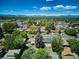Wide aerial view of a neighborhood featuring mature trees and mountain views in the distance at 1852 S Decatur St, Denver, CO 80219