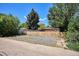 Backyard with gravel parking, surrounded by wooden fence and mature trees at 1852 S Decatur St, Denver, CO 80219