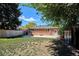 Spacious backyard with a brick house, patio, storage shed, and a wooden fence at 1852 S Decatur St, Denver, CO 80219