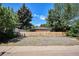 Wide backyard showcasing a gravel lot, surrounded by a wooden fence and foliage at 1852 S Decatur St, Denver, CO 80219