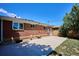 A backyard showcasing a brick home, concrete patio, and lush greenery, ideal for relaxation at 1852 S Decatur St, Denver, CO 80219