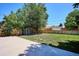 Fenced backyard with shed, grass, and a concrete patio, provides space for outdoor activities at 1852 S Decatur St, Denver, CO 80219