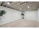 Finished basement with neutral carpet and exposed ceiling at 1852 S Decatur St, Denver, CO 80219