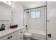 Updated bathroom with white subway tile, dark fixtures, and a combination shower/tub at 1852 S Decatur St, Denver, CO 80219