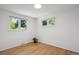 Bright bedroom featuring hardwood floors and two windows providing ample natural light at 1852 S Decatur St, Denver, CO 80219
