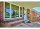Charming front entrance of a red brick house with a covered porch and large windows at 1852 S Decatur St, Denver, CO 80219
