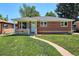 Beautiful brick home with a covered porch and well-kept lawn, offering classic curb appeal in a mature neighborhood at 1852 S Decatur St, Denver, CO 80219