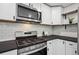 Close up of stainless steel stove and microwave, white backsplash and dark countertops at 1852 S Decatur St, Denver, CO 80219