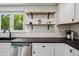 The kitchen has stainless steel appliances, black countertops, and bright lighting at 1852 S Decatur St, Denver, CO 80219
