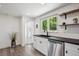 The updated kitchen has stainless steel appliances, and a view to the backyard at 1852 S Decatur St, Denver, CO 80219