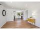 Open-concept living room showcasing hardwood floors, white walls, and seamless transition to a modern, updated kitchen at 1852 S Decatur St, Denver, CO 80219